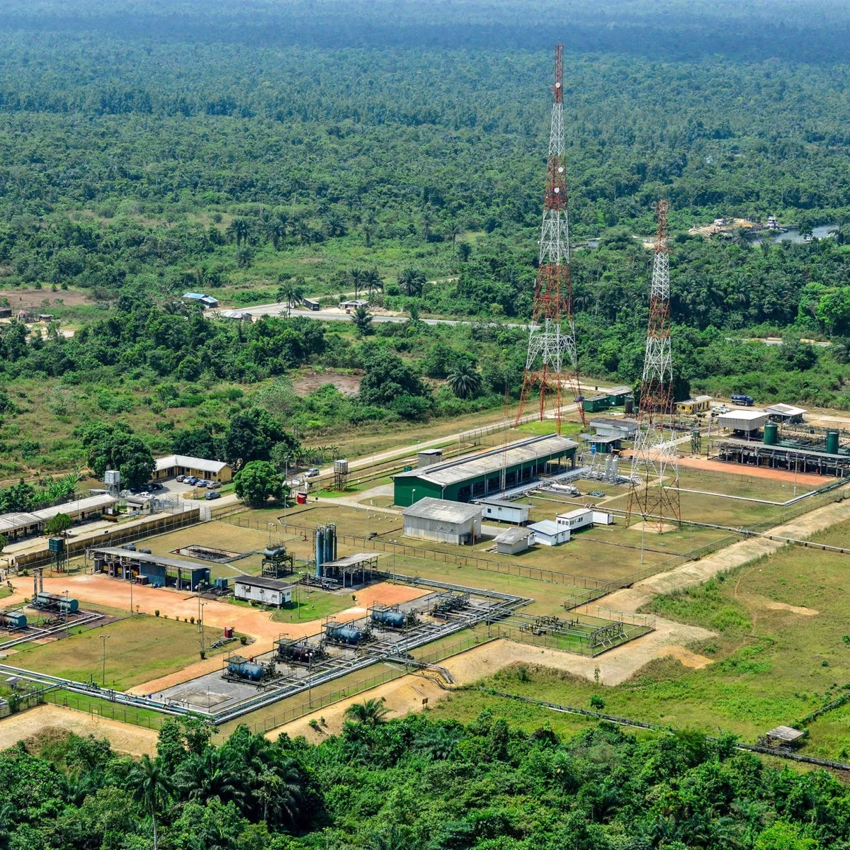 Aerial view of a gas plant and flowstation surrounded by forest